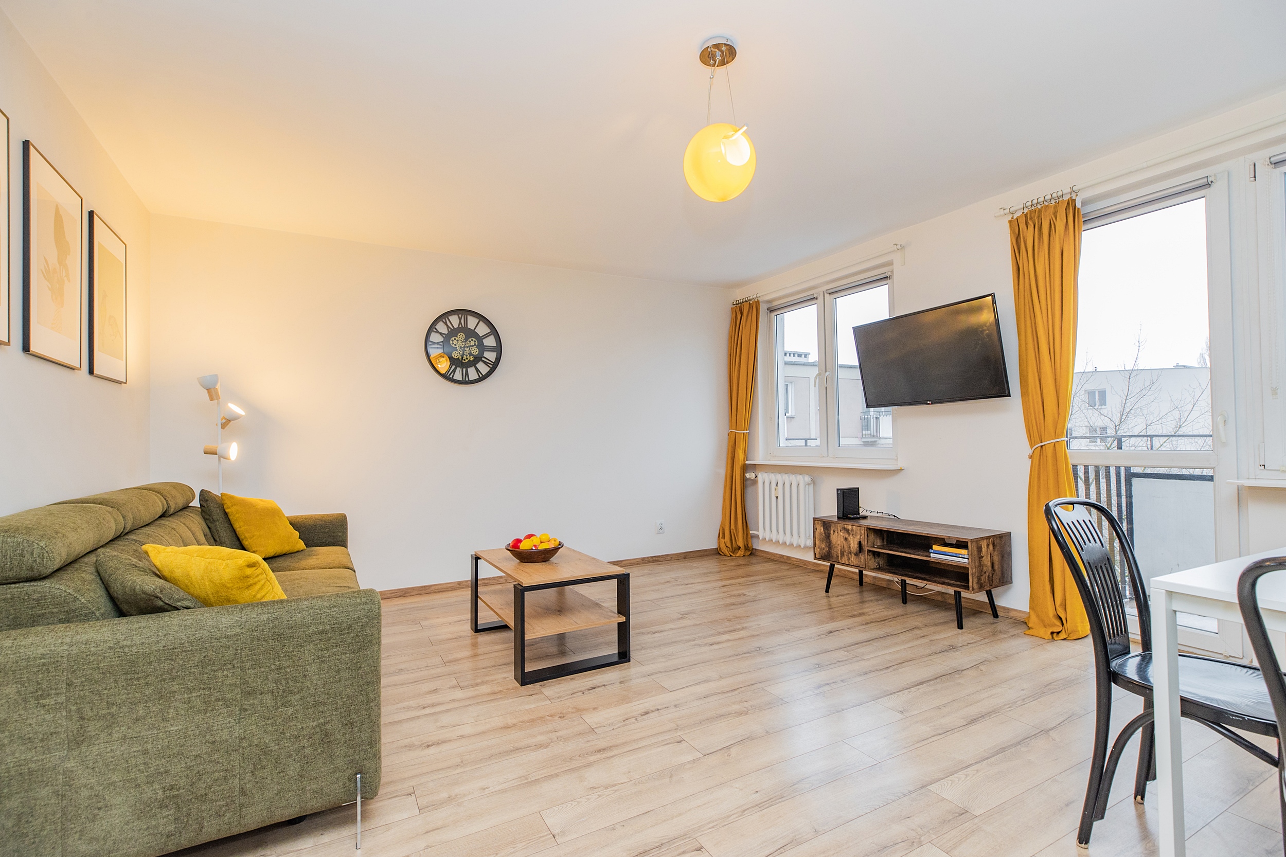 Salon apartamentu Bonifraterska 16/11 z sofą, telewizorem i wyjściem na balkon