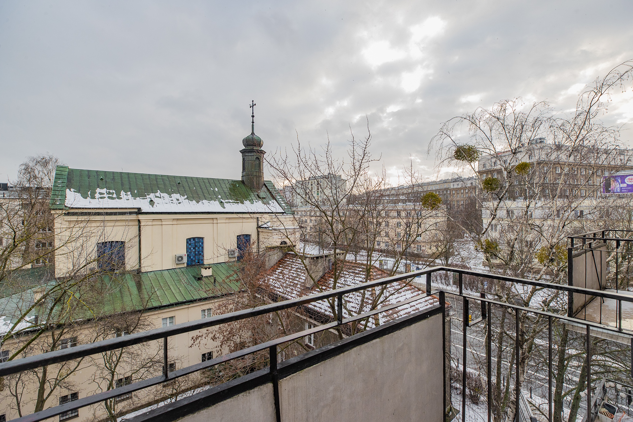 Balkon z widokiem na dziedziniec i sąsiedni kościół